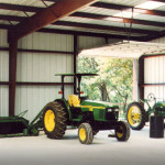 Inside steel farm shop with tractors and red steel framing