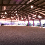 Interior of covered riding arena with dirt floor